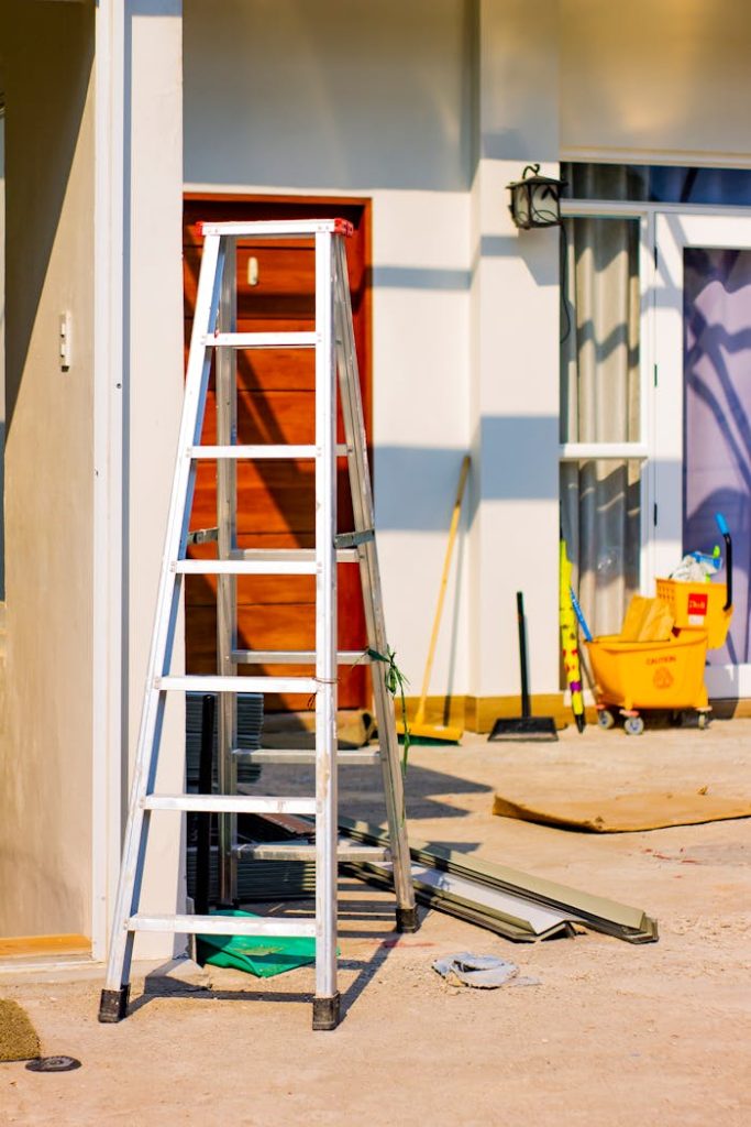 The Art of Drawing Readers In: Your attractive post title goes here An outdoor home renovation scene featuring a ladder and various tools indicating ongoing construction work.
